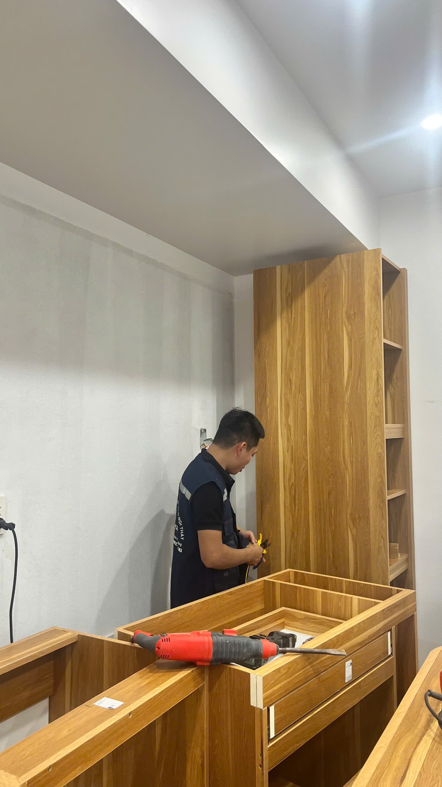 Thợ GOMITA mặc đồng phục lắp tủ gỗ tại công trình khách hàng